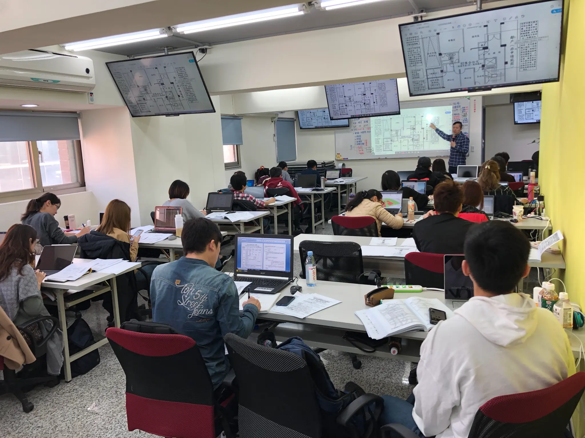 教室授課現場,學員使用筆電閱讀圖說並參與討論